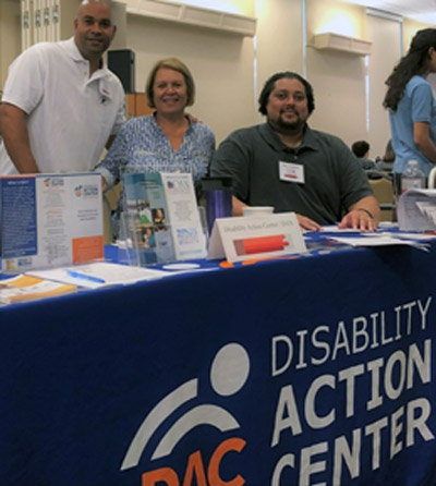 From left at the DAC table during the symposium are assistive technology specialist Dwight Phillips, board president Kim Scott and independent living specialist David Colefield
